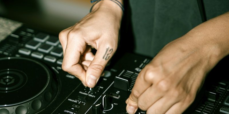 Tangan DJ menyesuaikan knob pada controller Pioneer - belajar DJ pemula
