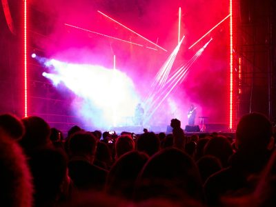 Kerumunan penonton menyaksikan panggung festival dengan lampu terang