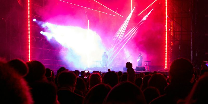 Kerumunan penonton menyaksikan panggung festival dengan lampu terang