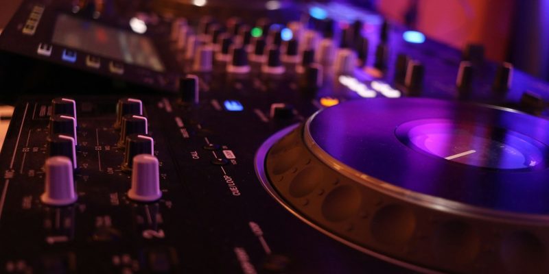 DJ sedang memutar musik di turntable dan mixer