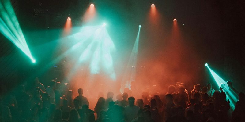 Kerumunan penonton menari di bawah lampu panggung festival musik