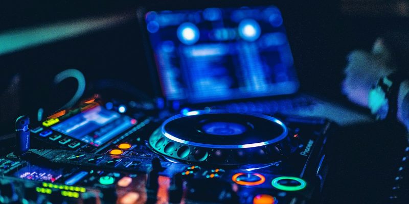 DJ mixer menyala dengan latar lampu panggung